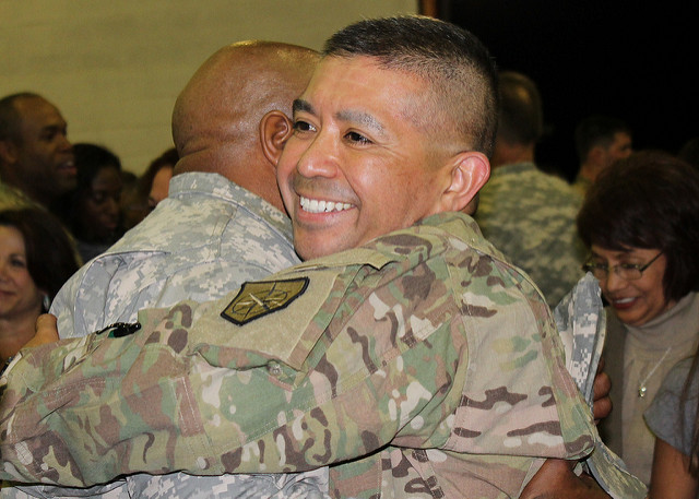 Soldiers hugging upon the return of one soldier from deployment.